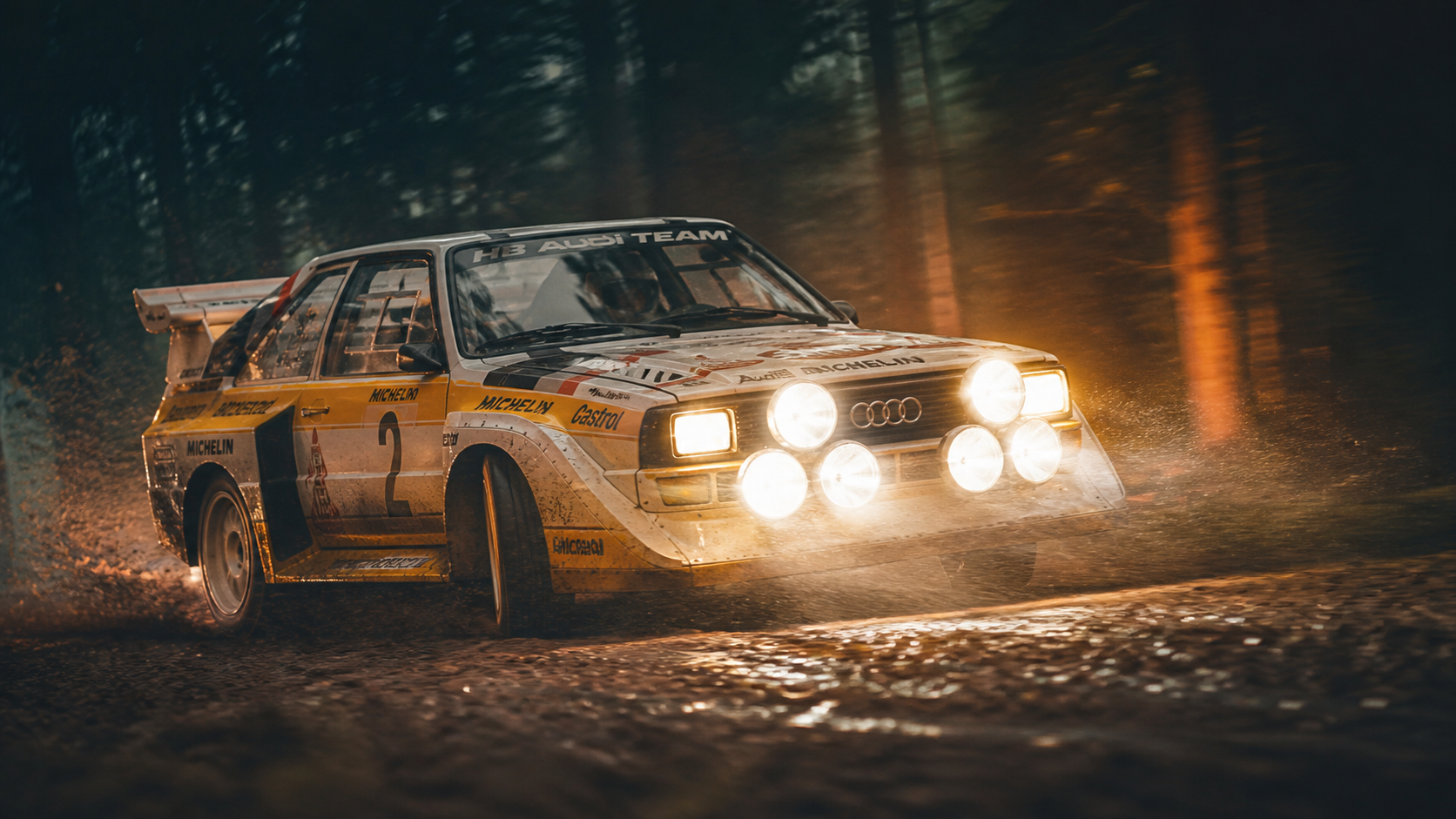 Historic Audi Quattro rally car at night on a forest stage